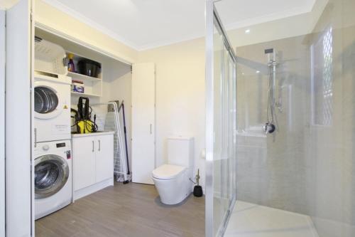 a bathroom with a washing machine and a washer at Snowgum Bright Retreat - 2 in Bright
