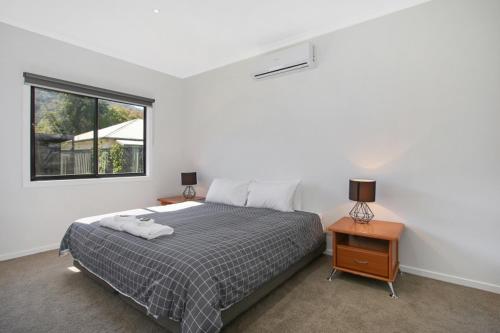 a bedroom with a large bed and a window at Snowgum Bright Retreat - 2 in Bright