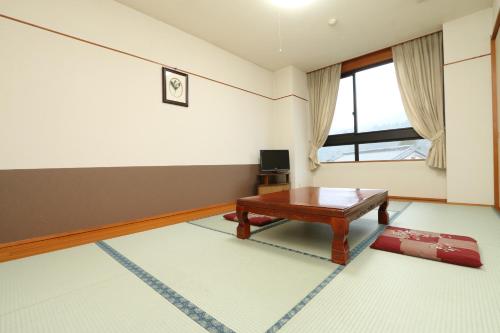 a living room with a table and a window at Oze Shinkousou in Katashina