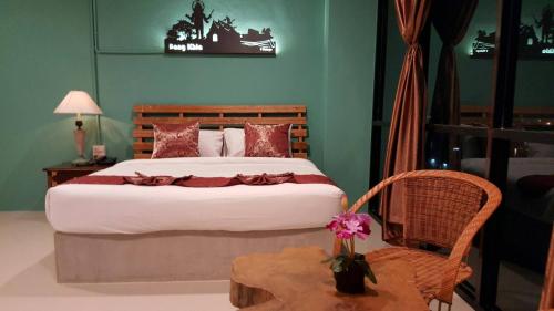 ein Schlafzimmer mit einem großen Bett und einem Stuhl in der Unterkunft T Vintage in Bang Khla