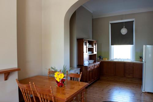 una cocina con una mesa con flores. en Webster Apartment en Ballarat