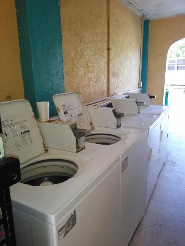 a row of white washing machines in a room at South Beach Inn - Cocoa Beach in Cocoa Beach