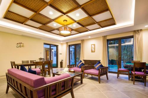 a living room with chairs and tables and a ceiling at Sanya Yalong Bay Villas & Spa in Sanya