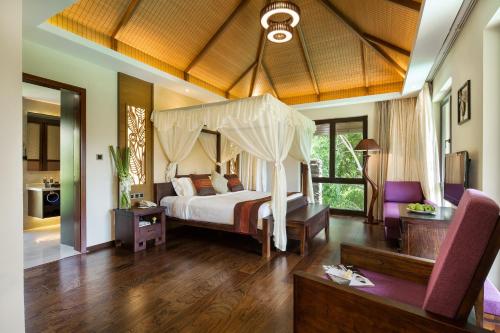 a bedroom with a bed with a canopy at Sanya Yalong Bay Villas & Spa in Sanya