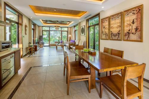 a dining room with a wooden table and chairs at Sanya Yalong Bay Villas & Spa in Sanya