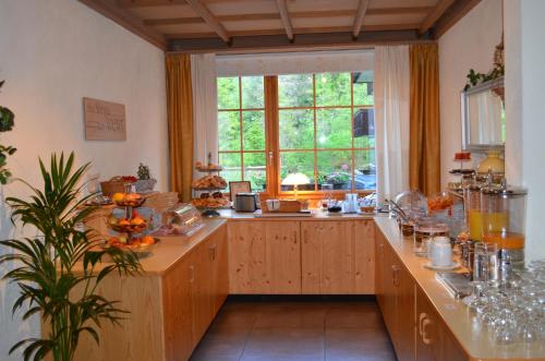a large kitchen with a large window and a counter at Bernerhof Swiss Quality Hotel in Kandersteg