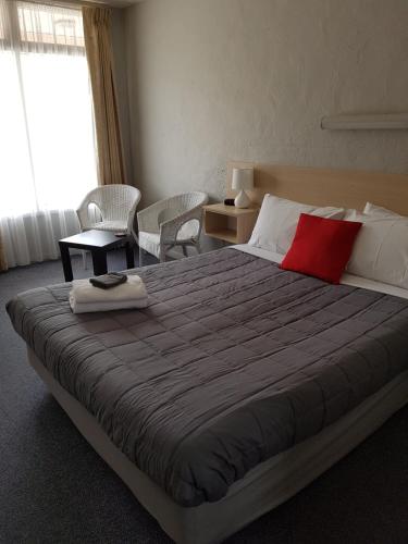 1 dormitorio con cama grande y almohada roja en Belmore Motor Inn, en Yarrawonga