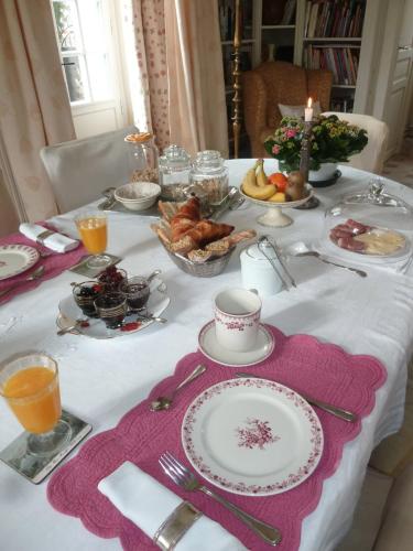un tavolo con una tovaglia bianca con del cibo sopra di Clos de la Rose a Saint-Cyr-sur-Morin