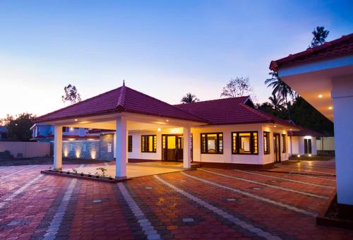 a house with a brick driveway in front of it at Le Coffee Resort in Sultan Bathery