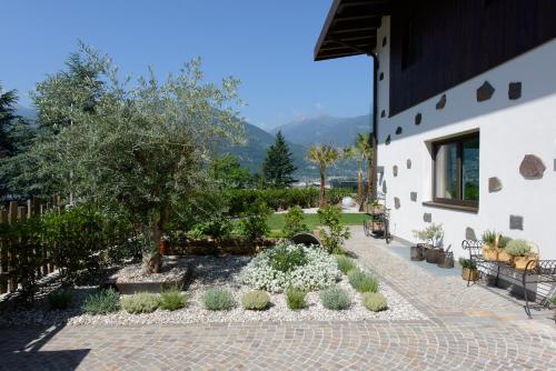 a courtyard with a tree and white flowers at Moar Lodge in Postal