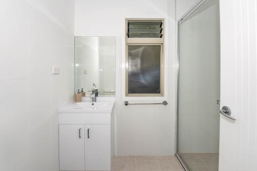 a white bathroom with a sink and a mirror at Oakey Creek Private Retreat in Gheerulla