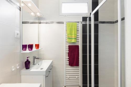 une salle de bain blanche avec un lavabo et une douche dans l'établissement BRASSENS - Quartier Sainte Thérèse, à Rennes