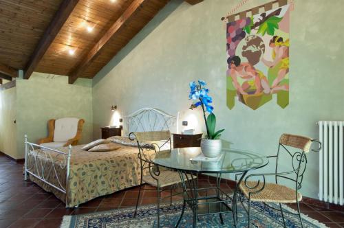 a bedroom with a bed and a table and chairs at Trattoria Del Bivio in Cerretto Langhe