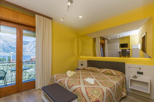 1 dormitorio con 1 cama y balcón en Garnì Casa Rabagno, en Malcesine