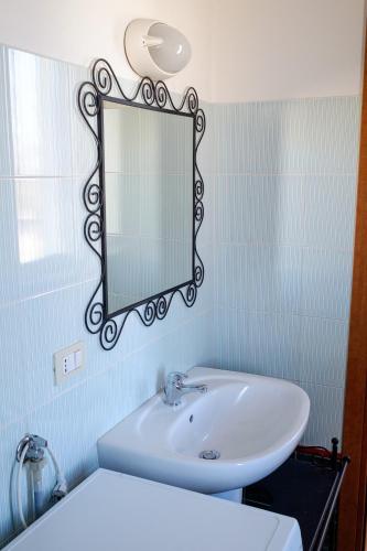a bathroom with a sink and a mirror on the wall at Residence Shopping Outlet in Novi Ligure