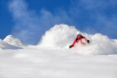 a person is skiing down a snow covered slope at Aparthotel AlpTirol in Kaltenbach