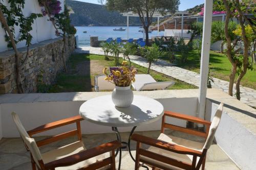 a vase of flowers sitting on a table with two chairs at Agrilia Apartments & Studios in Vathi