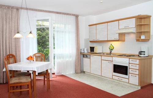 una cucina con tavolo e tavolo e sedie bianchi di Haus Buchenhof a Heringsdorf