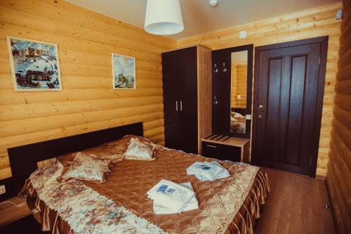 a bedroom with a bed in a room with wooden walls at Yasnaya Polyana in Arzamas