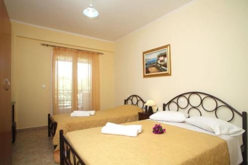 una habitación de hotel con 2 camas con flores. en Eleana Studios, en Lefkada