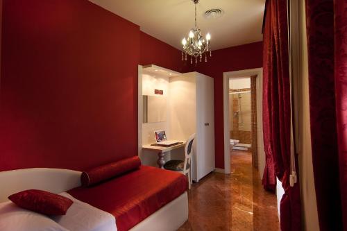 czerwona sypialnia z łóżkiem i biurkiem w obiekcie Hotel Fellini a Fontana di Trevi w Rzymie