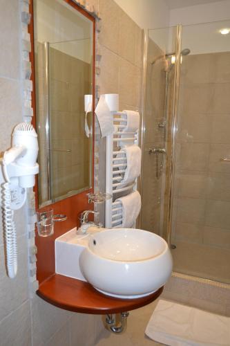 a bathroom with a sink and a shower at Hotel Slamený dom in Košice