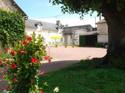 une maison avec une allée avec un arbre et des fleurs dans l'établissement Les Roulottes de Cuzay, à Roiffé