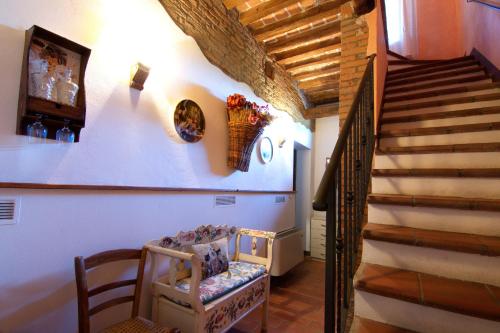 a hallway with a staircase and a chair and a stair case at Agriturismo La Cascinetta in Pieve di Cento