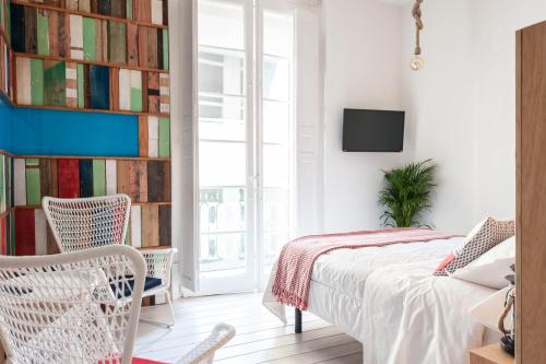 a bedroom with a bed, desk, and bookshelf at Urban Suite Santander in Santander