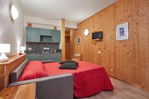 Habitación con cama con manta roja en Appartamenti Carlotta, en Arabba