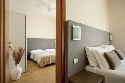 Habitación con dormitorio con cama y espejo. en Hotel Miramare, en Gabicce Mare