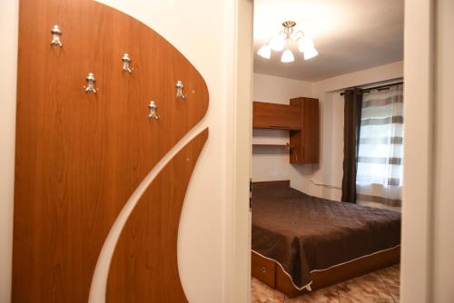 - une chambre avec un lit et un mur en bois dans l'établissement Chic Apartment Near City Center, à Cluj-Napoca