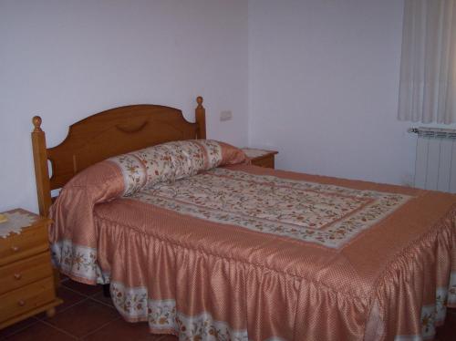a bedroom with a bed with a wooden headboard and a table at Casa Tere in Miller