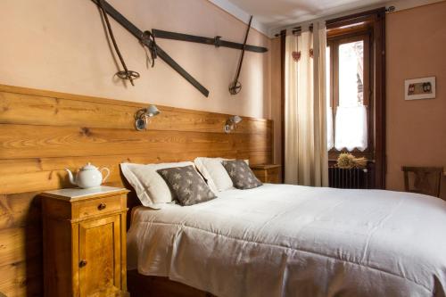 a bedroom with a bed with a wooden head board at Tre Alberi Liberi in Alagna Valsesia