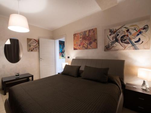 a bedroom with a bed with two lamps and paintings on the wall at Castiglione Residence in Foggia