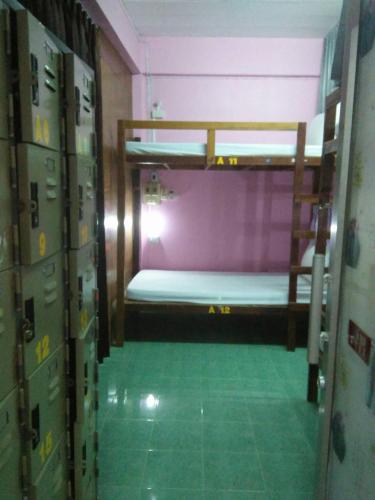 a room with a bunk bed and a green floor at Lucky Homestay in Haad Rin