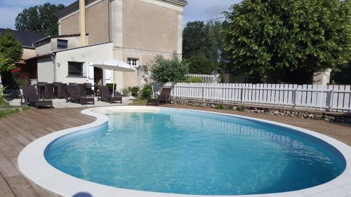 a large swimming pool in a yard with a white fence at Logis De La Motte in Artannes-sur-Thouet