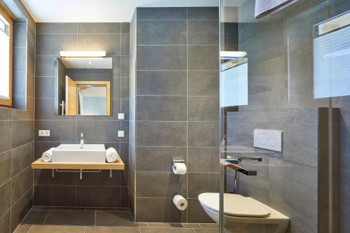 a bathroom with a toilet and a sink at Residenz Drachenstein Wildschönau in Niederau