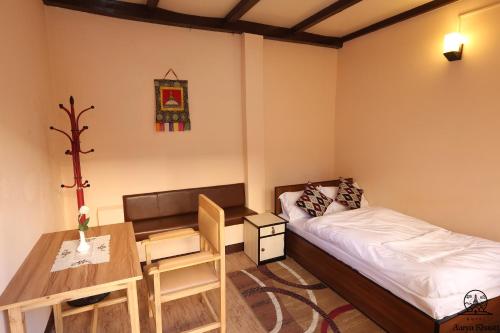Aarya Chaitya Inn في كاتماندو: غرفة صغيرة بها سرير ومكتب