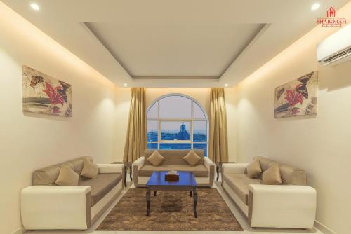 a living room with two couches and a table at فندق شروره بلازا الفندقية in Sharurah