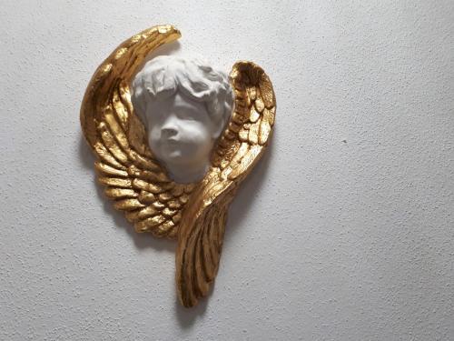 a gold object with a face on a wall at Landhaus & Apartment Taxach in Ried im Zillertal