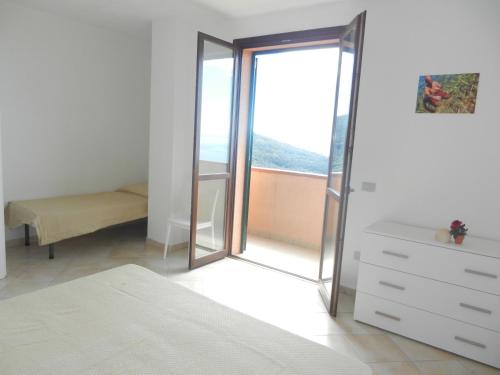 a bedroom with a mirror and a dresser and a window at Castello 9 in Isola del Giglio
