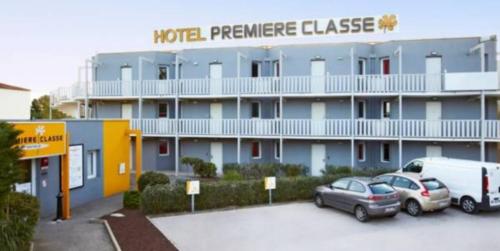 a hotel with two cars parked in a parking lot at Première Classe Martigues in Martigues