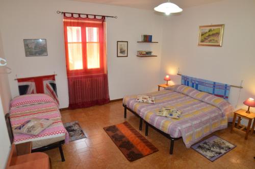 a bedroom with a bed and a chair and a window at La Casetta in Stazzano