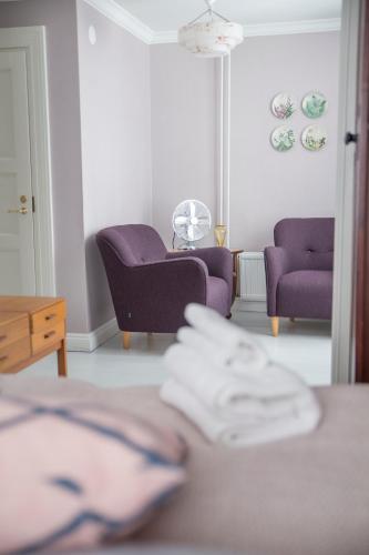 a living room with two purple chairs and a table at Hotelli Punkaharju in Punkaharju