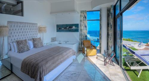 a bedroom with a bed and a view of the ocean at Sea Star Cliff in Gansbaai