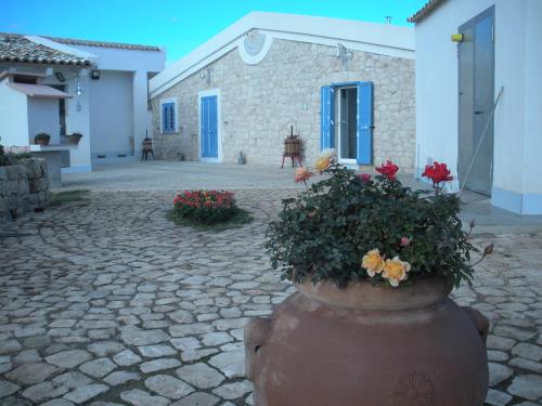 a large vase with flowers in front of a building at Casa vacanze La Meridiana in Donnalucata
