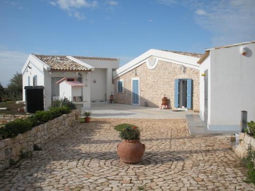 une maison dotée d'une passerelle en pierre avec une plante en pot dans l'établissement Casa vacanze La Meridiana, à Donnalucata