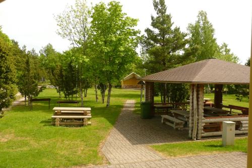 a picnic area with benches and a gazebo in a park at Pähklimäe Laagrikeskus in Vanamõisa