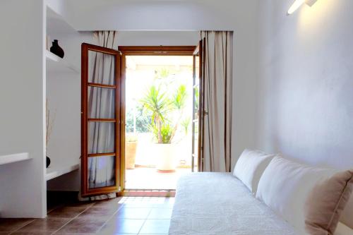 a living room with a couch and a sliding glass door at Apartment Kalypso in Agia Anna Naxos